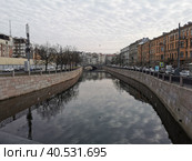 Набережная реки Карповки, в воде отражаются деревья и небо с облаками, вдали виден Силин мост (2021 год). Стоковое фото, фотограф Елена Яворская / Фотобанк Лори