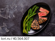 Tuna steak fried in sesame seeds served with asparagus. Стоковое фото, фотограф Татьяна  Бральнина / Фотобанк Лори