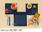 Handmade geometric Japanese Sashiko embroidery with white threads on blue cotton fabric, accessories, fruits and a teapot with green tea. Pastel calming coral background. Flat lay, close-up, top view. Стоковое фото, фотограф Виктория Катьянова / Фотобанк Лори