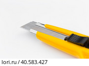 The yellow stationery knife isolated on white background. Стоковое фото, фотограф Сергей Толмачёв / Фотобанк Лори