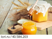 Honey background. Sweet honey in glass jar on wooden background. Стоковое фото, фотограф Сергей Толмачёв / Фотобанк Лори