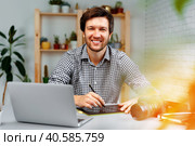 Smiling man photographer or retoucher working from home. Стоковое фото, фотограф Сергей Толмачёв / Фотобанк Лори