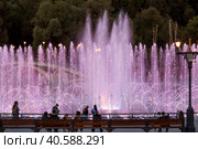 Light and music fountain on a summer evening. Natural Museum-reserve "Tsaritsyno". Colorful fountain in Tsaritsyno Park at night. (2023 год). Редакционное фото, фотограф Photojuli / Фотобанк Лори