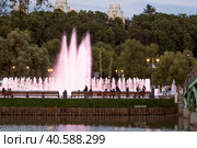 Light and music fountain on a summer evening. Natural Museum-reserve "Tsaritsyno". Colorful fountain in Tsaritsyno Park at night. (2023 год). Редакционное фото, фотограф Photojuli / Фотобанк Лори