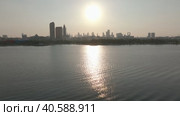 Drol flies over the bay of the sea at sunset, in the background of the skyscrapers of Dubai. Стоковое видео, видеограф Aleksey Kidisyuk / Фотобанк Лори