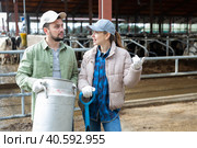 Farmer couple standing with milk churn at livestock farm and talking. Стоковое фото, фотограф Яков Филимонов / Фотобанк Лори
