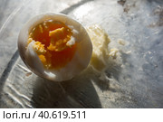 Очищенное вареное надкусанное яйцо с куском сливочного масла/ Boiled peeled bitten egg with a piece of butter on a transparent plate. Стоковое фото, фотограф Iva Noel / Фотобанк Лори