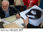 Художник-мультипликатор Юрий Норштейн подписывает книги читателям на книжном фестивале "Красной площади" в центре города Москвы, Россия (2023 год). Редакционное фото, фотограф Николай Винокуров / Фотобанк Лори