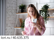 Surprised woman having video call with friend, chatting on mobile phone at home. Стоковое фото, фотограф Оксана Гильман / Фотобанк Лори