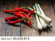 Pile of thai Bird's Eye Chilis with lemongrass on a old wooden background. Стоковое фото, фотограф Всеволод Белоусов / Фотобанк Лори