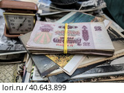 Пачка советских банкнот лежит на старых фотографиях/ Old photographs, a stack of banknotes tied with a rubber band and a vintage alarm clock. Стоковое фото, фотограф Iva Noel / Фотобанк Лори
