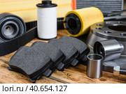 New car parts on a wooden table. Selective focus on brake pads. Car maintenance and repair concept. Стоковое фото, фотограф Никита Бурденков / Фотобанк Лори