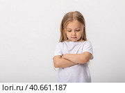 Negative human emotions, reactions and feelings. Isolated shot of moody displeased angry little girl crossing arms on her chest, pouting lips, having offended facial expression, being capricious. Стоковое фото, фотограф Ирина Михайличенко / Фотобанк Лори