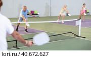 Man and woman training to play pickleball tennis on the pickleball cour. Стоковое фото, фотограф Яков Филимонов / Фотобанк Лори