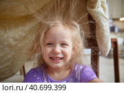 Static electricity electrified the hair of a little girl sitting under a synthetic blanket. Стоковое фото, фотограф Кутина Татьяна / Фотобанк Лори