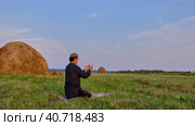A Muslim senior man prays in an hayfield. Стоковое фото, фотограф Ирина Кононова / Фотобанк Лори