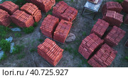 Pallets of bricks for construction. Outdoor storage. Warehousing of large quantities of bricks. Aerial view. Стоковое видео, видеограф Георгий Мякишев / Фотобанк Лори