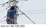 Electricity. An electrician installs an electric energy meter by climbing an electric pole. (2023 год). Редакционное видео, видеограф Сергей Медведев / Фотобанк Лори