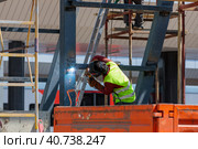 A man-welder fastens iron girders with a welding machine. Construction of the station. Стоковое фото, фотограф Юрий Поздников / Фотобанк Лори