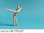 Деревянный человечек выполняет физические упражнения, наклоняясь вперед и разводя руки в стороны. Стоковое фото, фотограф Лозовая Людмила / Фотобанк Лори