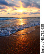 Sunset over sea. Beautiful sunset. Foamy waves roll over the sandy shore. Vityazevo, Anapa, Black Sea. Tourist mecca, health resort. Colorful clouds in the evening sky. The rays reflect off the water. Стоковое фото, фотограф Юлия Петровская / Фотобанк Лори