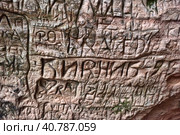 Natural cave in sandstone rock, former bank of Gauja river. Carved wall in Gutmanis cave in Sigulda, Latvia. (2016 год). Редакционное фото, фотограф Анна Кривицкая / Фотобанк Лори