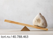 Stone on wooden swing or scales on abstract background, template for designer. Стоковое фото, фотограф Сергей Чайко / Фотобанк Лори