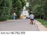 A cheerful little boy rides a running bike in a helmet outdoors. A happy child is engaged in an active sport. Protection. Life insurance and child safety. Стоковое фото, фотограф Photojuli / Фотобанк Лори