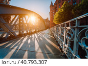 Metal arch bridge in the Speicherstadt of Hamburg with sunburst light during sunset golden hour (2018 год). Стоковое фото, фотограф Igor Tichonow / Фотобанк Лори