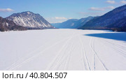 Горный Алтай зимой: Телецкое озеро. Вид с воздуха. Altai mountains in winter: Teletskoye lake. Aerial view. Стоковое видео, видеограф Евгений Романов / Фотобанк Лори