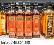 Оливковое масло Filippo Berio Chilli в бутылках на полке в супермаркете. Оливковое масло в бутылках. Выборочный фокус (2023 год). Редакционное фото, фотограф FotograFF / Фотобанк Лори