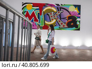 Люди идут на фоне граффитти с надписью "Москва" на павильоне фестиваля "Российская креативная неделя. Москва-фест" на Тверской улице в центре города Москвы, Россия (2023 год). Редакционное фото, фотограф Николай Винокуров / Фотобанк Лори