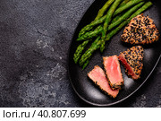 Tuna steak fried in sesame seeds served with asparagus. Стоковое фото, фотограф Татьяна  Бральнина / Фотобанк Лори