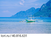 White banca boat in calm blue ocean, Seven Commandos Beach in background, El Nido, Philippines (2014 год). Стоковое фото, фотограф Igor Tichonow / Фотобанк Лори