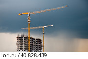 Строящийся жилой дом. Серые грозовые тучи на закате. Москва. Россия (2023 год). Редакционное фото, фотограф E. O. / Фотобанк Лори