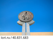 Памятник золотоискателям, город Магадан, Магаданская область, Россия. Скульптура в виде большой золотой монеты с барельефом (старатель, промывающий золото) и надписью "Один червонец". Редакционное фото, фотограф Андрей Степанов / Фотобанк Лори