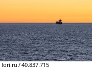 Cargo ship at sea. Beautiful evening seascape. View of the ship at sea at sunset. Sea container transportation. Maritime transport logistics. Minimalist landscape. Great for backgrounds and designs. Стоковое фото, фотограф Андрей Степанов / Фотобанк Лори