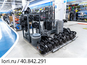 Спортивная тяжелая штанга и другое оборудование для фитнеса, продаваемое в магазине. Отдел спортивных товаров. Продажа оборудования для тяжелой атлетики (2023 год). Редакционное фото, фотограф FotograFF / Фотобанк Лори