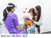 Mom and her infant daughter at the doctor's appointment. Healthy lifestyle concept. The doctor fills out the health questionnaire. Стоковое фото, фотограф Ирина Михайличенко / Фотобанк Лори