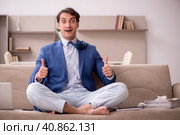 Young male employee working from home during pandemic. Стоковое фото, фотограф Elnur / Фотобанк Лори