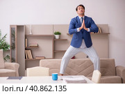 Young male employee working from home during pandemic. Стоковое фото, фотограф Elnur / Фотобанк Лори