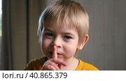 Boy with finger on lips. Child saying hush gesturing for quiet or shushing doing silence gesture Shh. Стоковое видео, видеограф Марина Демидюк / Фотобанк Лори