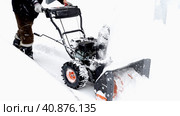 Snowblower removes snow, a man cleans the yard outside. Стоковое фото, фотограф Igor Skripachev / Фотобанк Лори