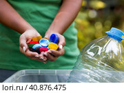 A woman's hands hold the lids of plastic bottles for recycling and environmental conservation, reuse, garbage disposal. Clean the planet of plastic garbage. Стоковое фото, фотограф Photojuli / Фотобанк Лори