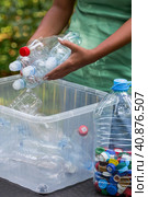 Container of plastic bottles. Garbage collection around the world. Clean the planet of plastic garbage. Ecology. A woman sorts garbage. Стоковое фото, фотограф Photojuli / Фотобанк Лори