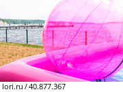 Inflatable large zorb ball in the pool for entertaining children and adults on the beach. A large pink inflatable balloon-zorb. Стоковое фото, фотограф Эдуард Белкин / Фотобанк Лори