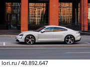 Gray Porsche Taycan car parked near business center, side view. Редакционное фото, фотограф Константин Григорьев / Фотобанк Лори