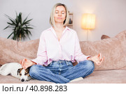 Calm middle aged woman relaxing on couch fingers makes mudra. Стоковое фото, фотограф Гладских Татьяна / Фотобанк Лори