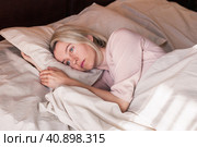 Unhappy sad middle aged woman sitting on bed at home. Стоковое фото, фотограф Гладских Татьяна / Фотобанк Лори