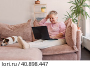Older smiling 60s woman sitting at home on sofa. Стоковое фото, фотограф Гладских Татьяна / Фотобанк Лори